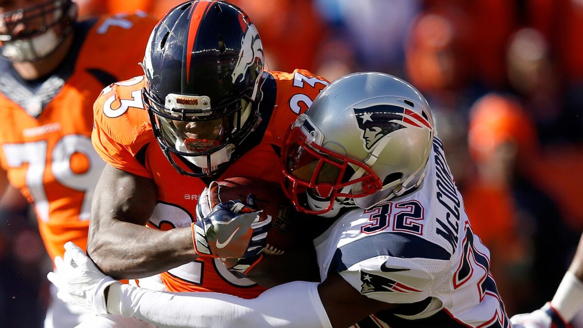 Broncos running back Ronnie Hillman is tackled by Patriots safety Devin McCourty after a gain in the AFC championship game.