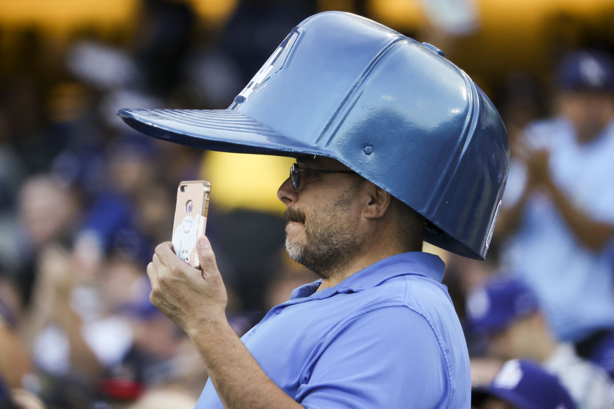 Un fanático de los Dodgers usa un gran sombrero.