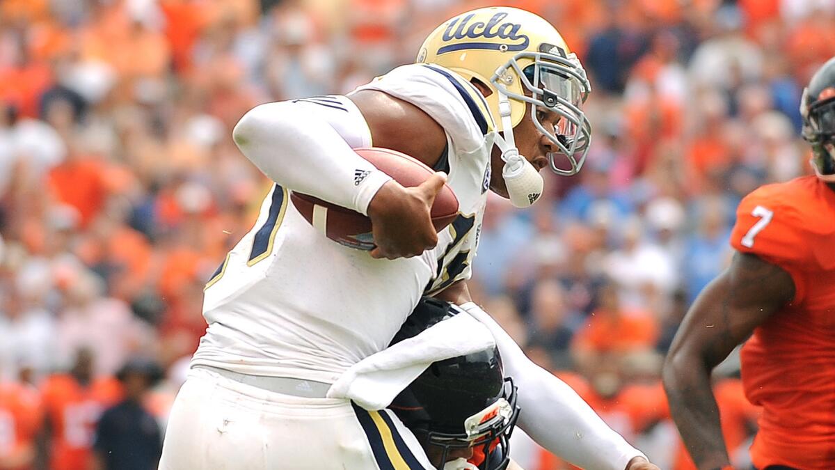 UCLA quarterback Brett Hundley scores a touchdown in the second half of the Bruins' 28-20 win over Virginia on Saturday.