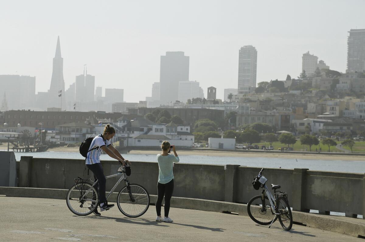 ARCHIVO - En esta foto de archivo del 17 de agosto de 2015, una pareja toma fotos de San Francisco desde el Parque Acuático. Un hombre de 20 años fue muerto a tiros cuando jugaba Pokémon Go en el lugar el 6 de agosto de 2016. (AP Foto/Eric Risberg, File)