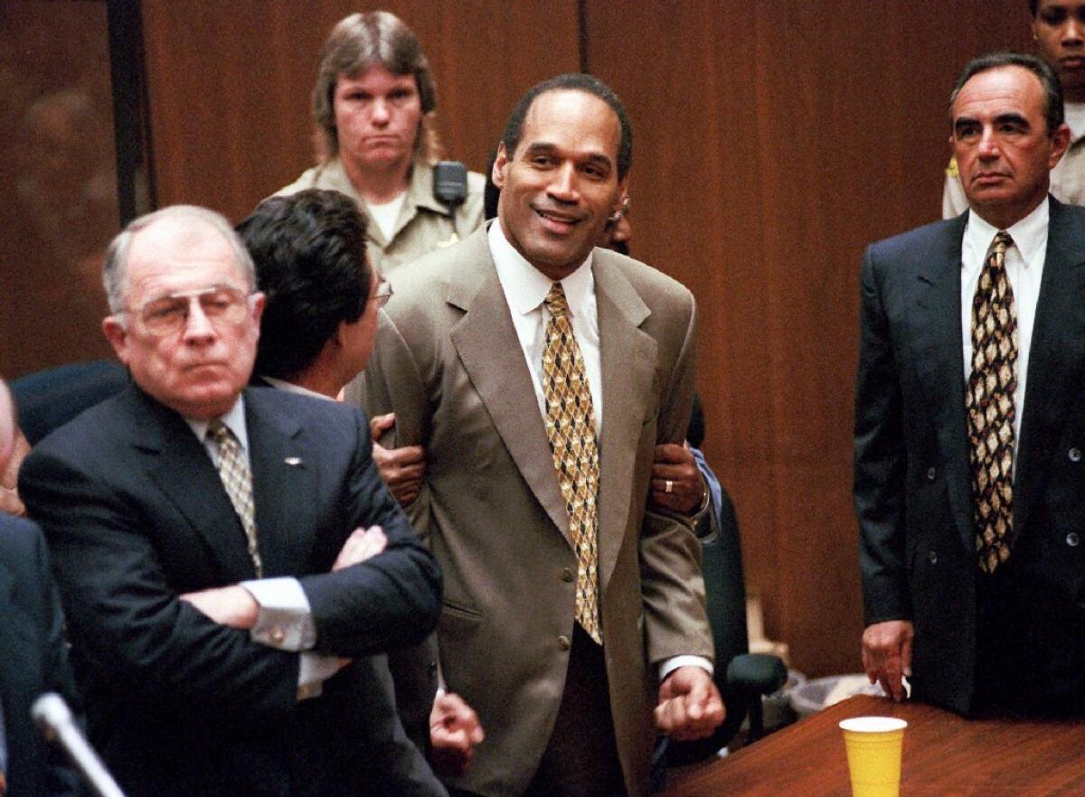 O.J. Simpson, center, reacts after being found not guilty of murder