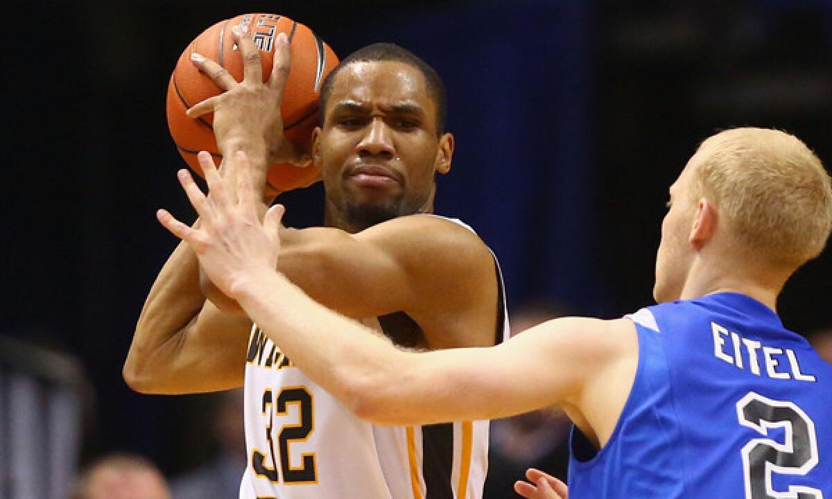 Wichita State's Tekele Cotton, left, looks to pass around Indiana State's Luca Eitel during the Shockers' Missouri Valley Conference title win on March 9.