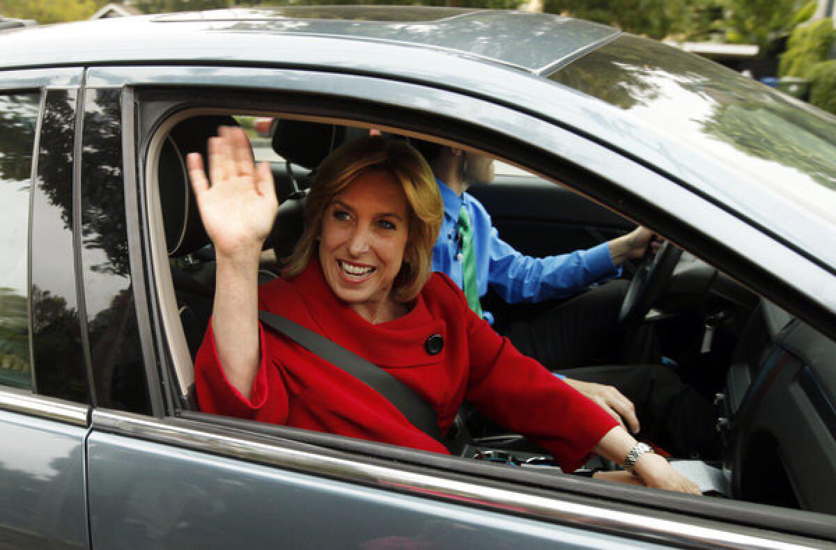 Wendy Greuel, waves to cameras on the way to take her 9-year-old son, Thomas Schramm, to school after voting on Election Day in May. Greul lost her bid for Los Angeles mayor, but may still consider a run for county supervisor, according to sources close to her.