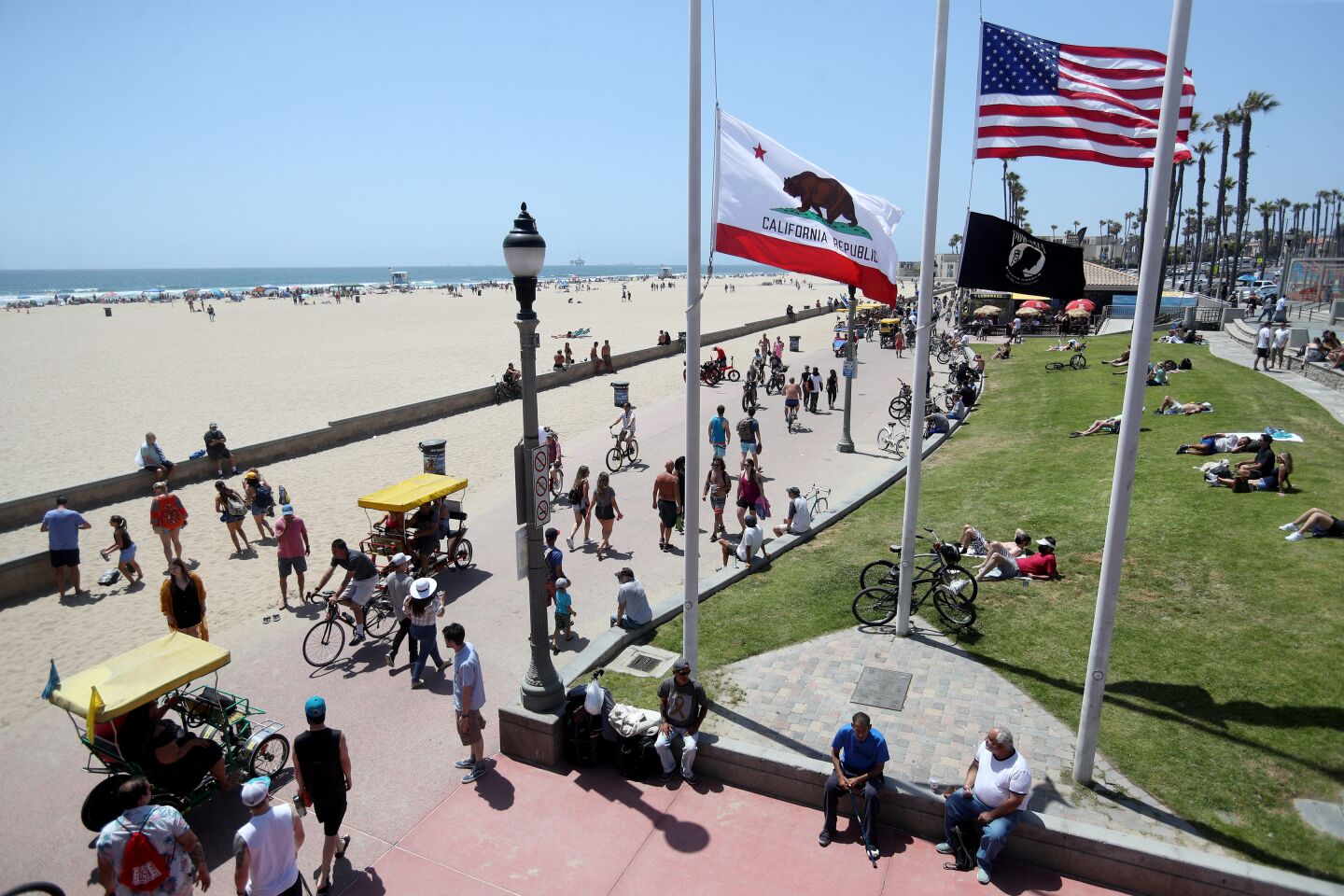 Crowds enjoy a sunny day near the Huntington Beach Pier on Saturday.
