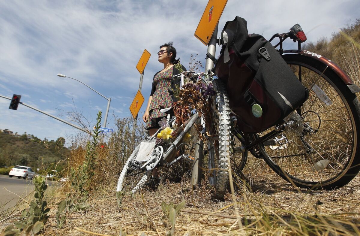 SDSU graduate student Sara Kazemi stands near the Montezuma Road ghost bike she and others worked to preserve in July. — Earnie Grafton