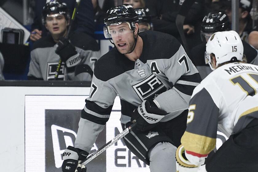 Los Angeles Kings center Jeff Carter, left, handles the puck while Vegas Golden Knights defenseman Jon Merrill defends during the second period of an NHL hockey game in Los Angeles, Saturday, Nov. 16, 2019. (AP Photo/Kelvin Kuo)