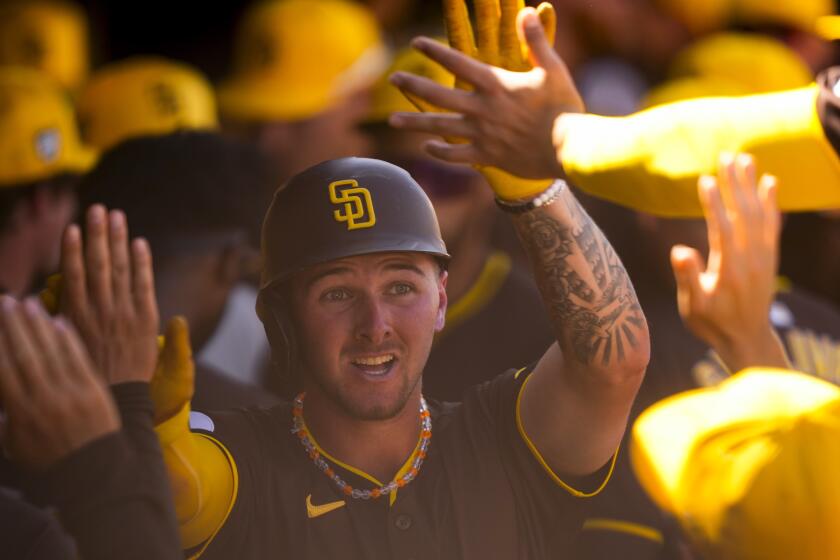 San Diego Padres' Jackson Merrill celebrates his home run against the Seattle Mariners in the dugout during the fourth inning of a spring training baseball game Monday, March 11, 2024, in Peoria, Ariz. (AP Photo/Lindsey Wasson)