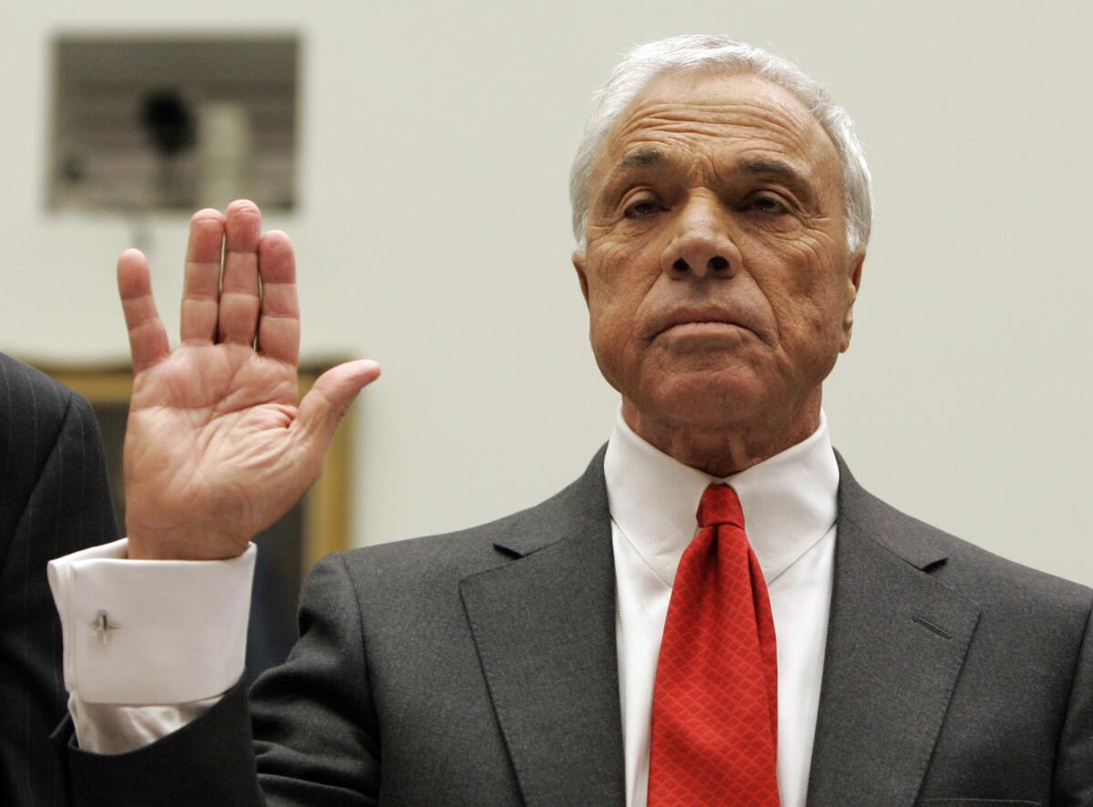 Angelo Mozilo raises one hand as he is sworn in at a hearing.