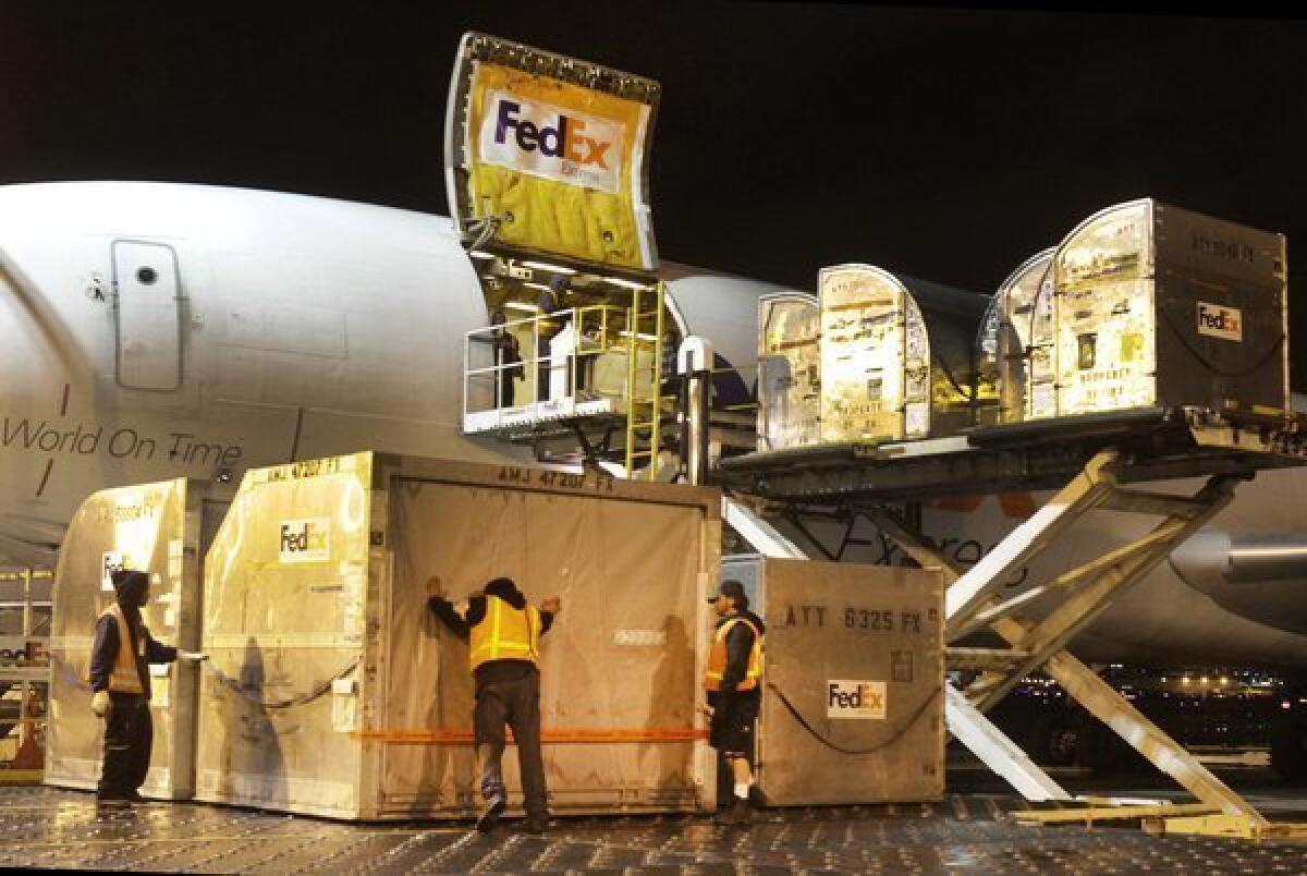Containers filled with packages are loaded on a cargo plane at the LAX FedEx facility.
