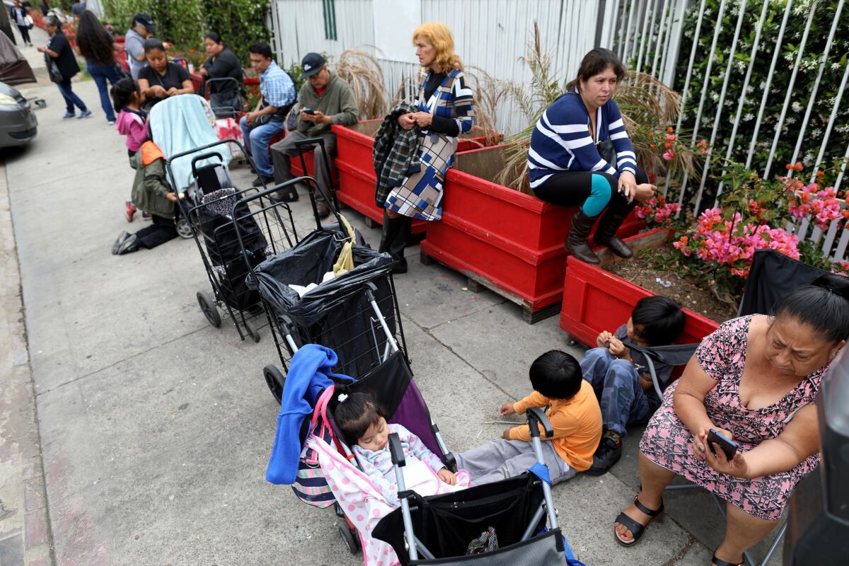 People wait in line for the St. Francis Center food bank to open in Los Angeles. (Gary Coronado / Los Angeles Times)
