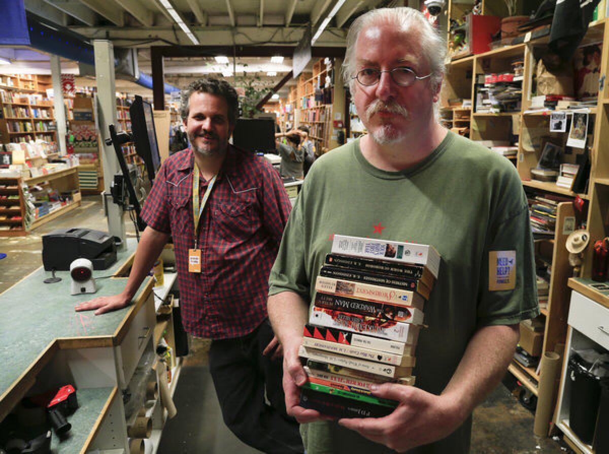 Tyson Birnbaum, left, and Keith Brooks pause at Powell's bookstore on Hawthorne Boulevard in Portland, Ore.