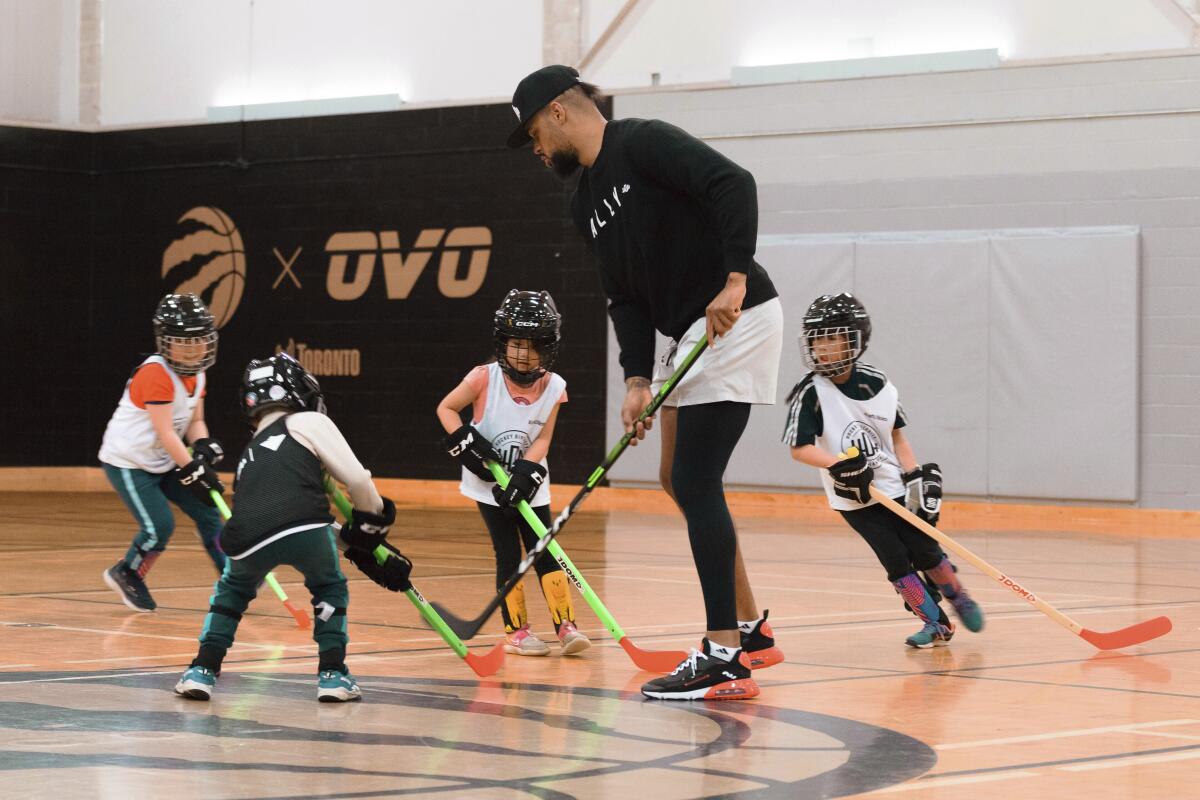 This June 12, 2022, photo, provided by Kasumi Kobo, shows Akim Aliu, co-founder of the Hockey Diversity Alliance and former professional hockey player, as he works with children during a ball hockey skills program, at the Malvern Recreation Centre, in Toronto, Ontario, Canada. The Hockey Diversity Alliance announced Thursday, June 16, 2020, it plans to expand the project into other cities on both sides of the border. (Kasumi Kobo via AP)