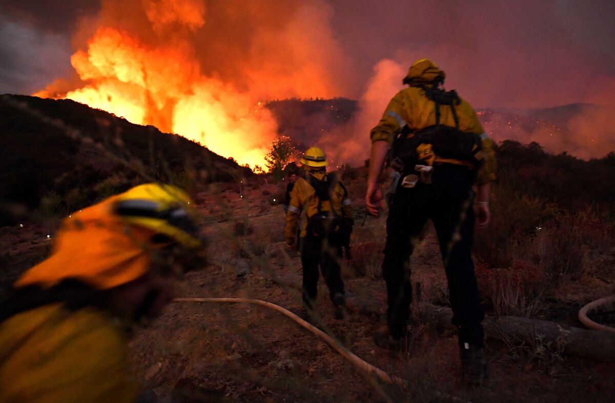 Firefighters make their way up a hill as the El Dorado fire approaches in Yucaipa on Saturday.