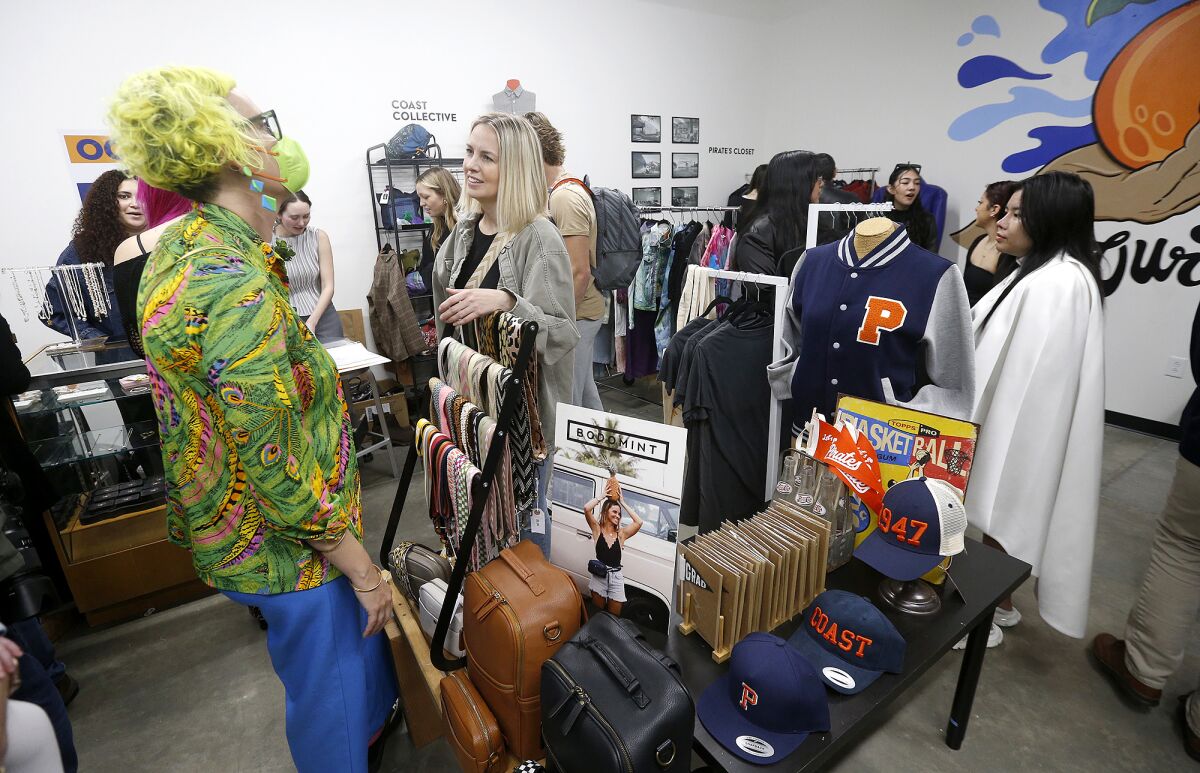 OCC alumna Rebecca Waldron, who created a line of fashionable diaper bags under the brand Bodomint, talks with a shopper.