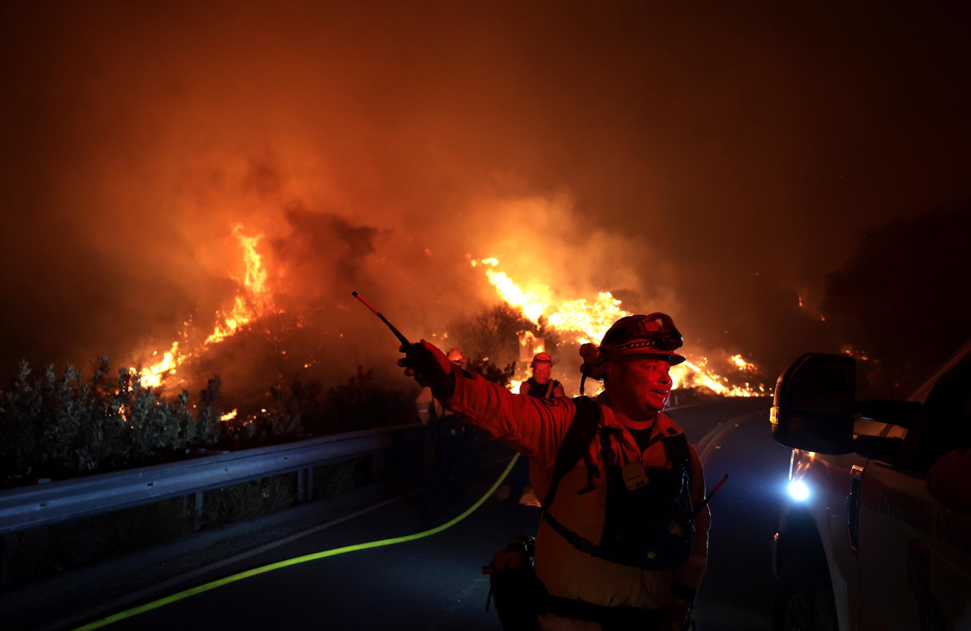 A fire crew silhouetted by flames.