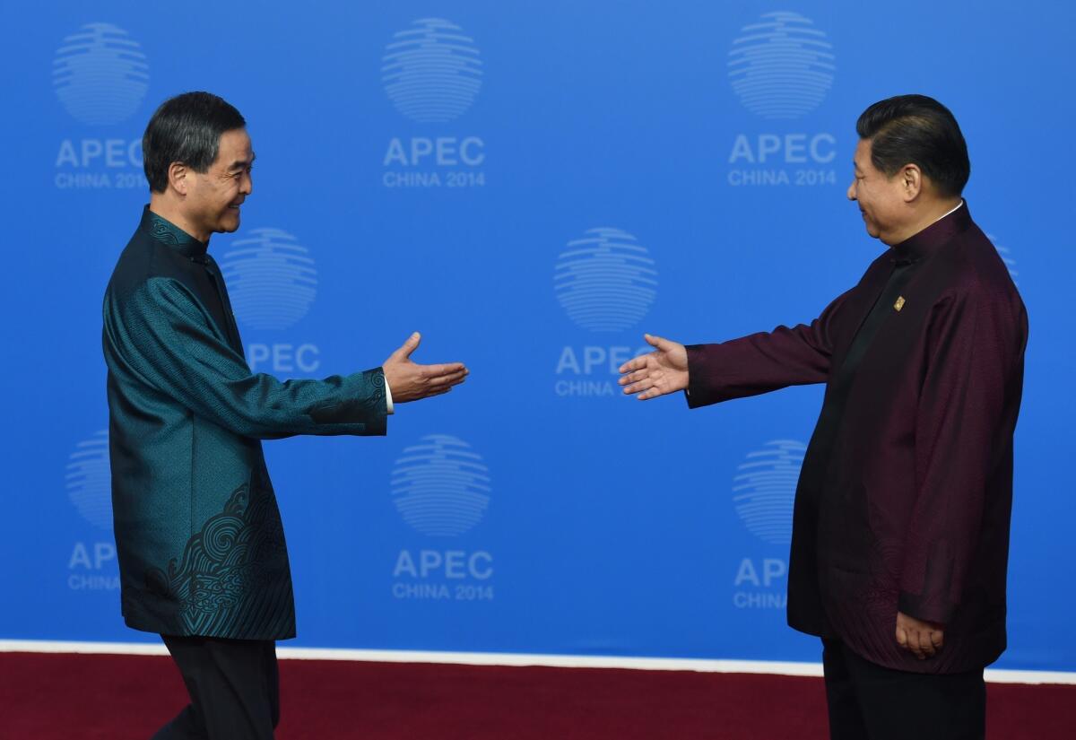 Hong Kong Chief Executive Leung Chun-ying, left, is welcomed by Chinese President Xi Jinping as he arrives for the Asia-Pacific Economic Cooperation summit banquet at the National Aquatics Center in Beijing on Monday.