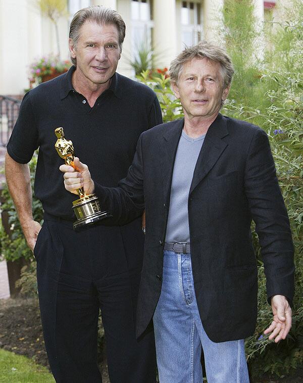Actor Harrison Ford presents director Roman Polanski with his Oscar at the 29th American Film Festival in Deauville on September 7, 2003 in France.