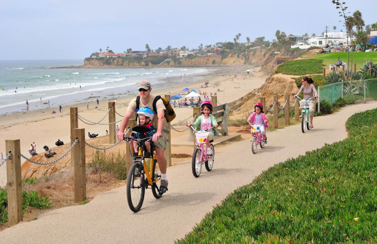 Actividades gratuitas para niños durante el mes de octubre. Una familia en bicicleta por Pacific Beach.