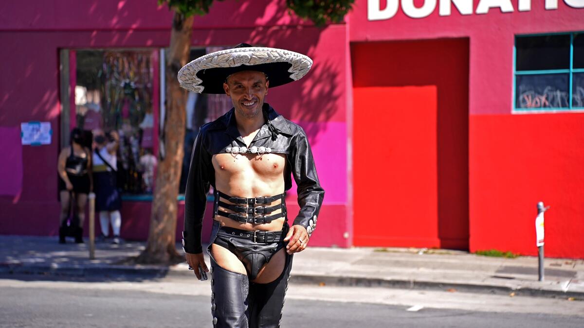 A man in a black leather sombrero, underwear and chaps.   