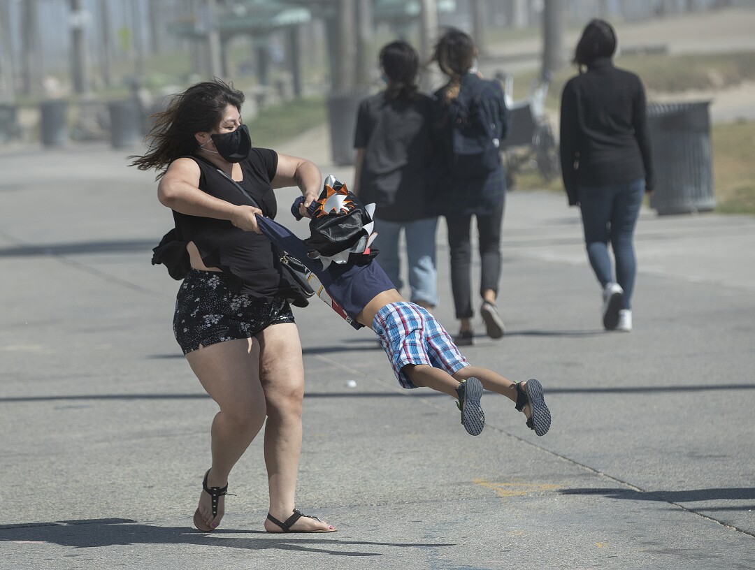 Bell Vasquez of Los Angeles gives her son Israel, 4, a spin on the boardwalk in Venice Beach.