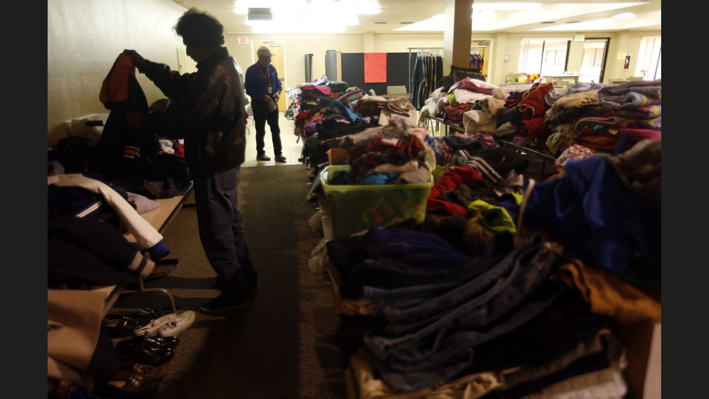 Manuel Mendoza sorts through donated clothing at the Bridge Church in Santa Rosa on Sunday.