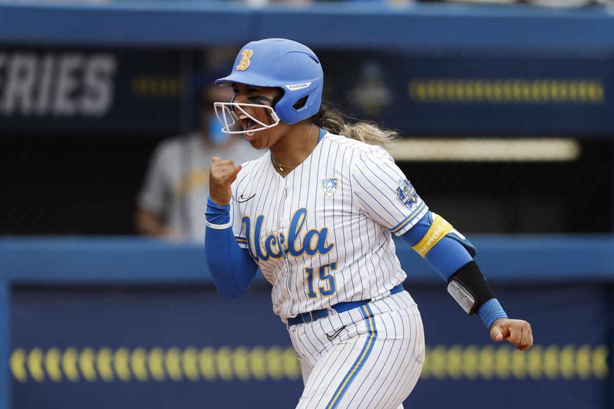 UCLA's Jordan Woolery pumps a fist and shouts as she rounds the bases after hitting a three-run home run 