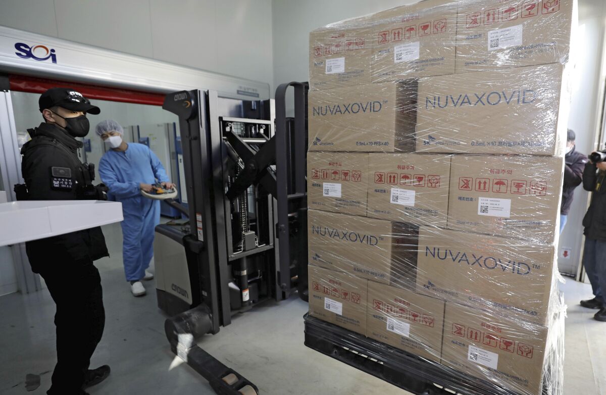A worker moves boxes carrying Novavax's COVID-19 vaccine