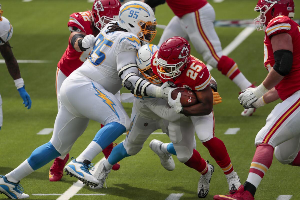 Chiefs running back Clyde Edwards-Helaire is tackled by Chargers defensive tackle Linval Joseph and Isaac Rochell.