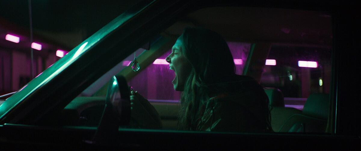 Andi Matichak as a woman screaming behind the wheel of a car in the movie "Son."