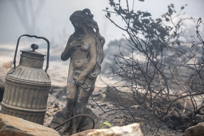 A statue singed by flames sits amid a home destroyed in the Bear fire on Thursday in Feather Falls, a town in Butte County.