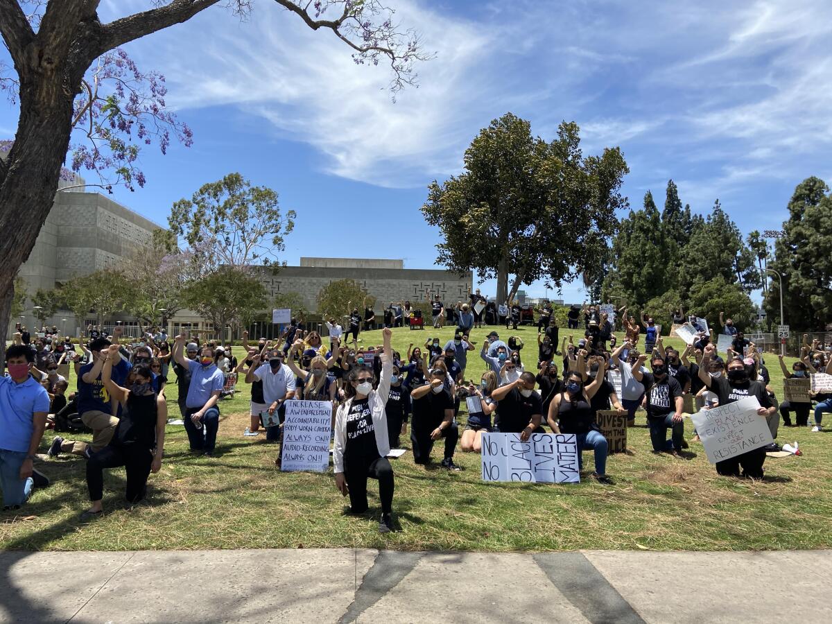 Hundreds kneel near the O.C. Sheriff's headquarters to protest police brutality.