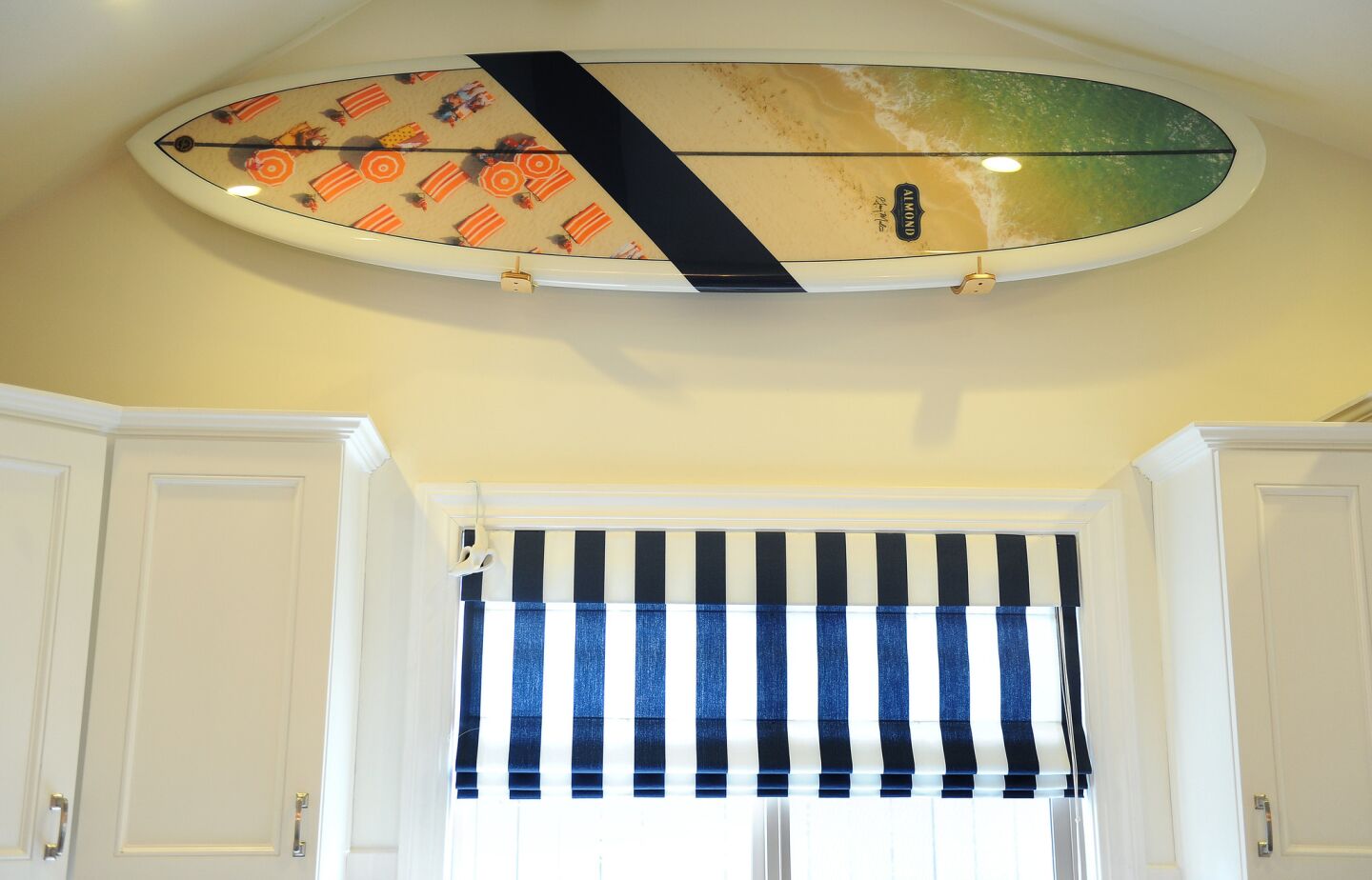 A Gray Malin and Almond surfboard is installed above the kitchen window.