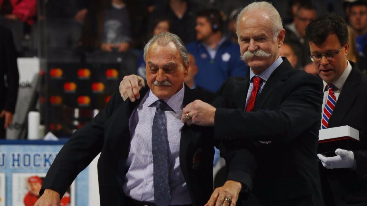 Rogie Vachon is honored for his induction into the Hockey Hall of Fame and is joined by Lanny McDonald, right, prior to the 2016 Hockey Hall of Fame Legends Classic game on Nov. 13