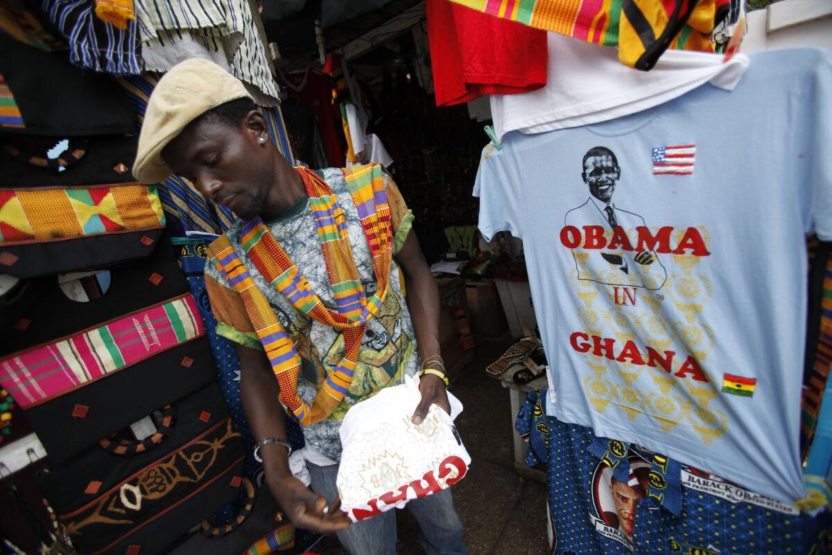 A vendor folds tee-shirts commemorating U.S. President Barack Obama's planned visit to Ghana, at a streetside stall in central Accra, Ghana Thursday, July 9, 2009.