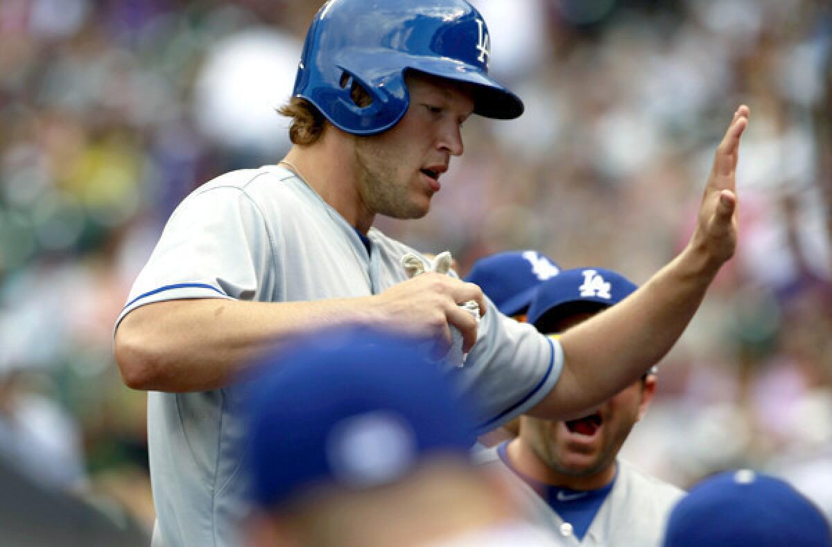 Dodgers pitcher Clayton Kershaw is congratulated by teammates after he drove in two runs against the Rockies with a single in the fifth inning Monday afternoon at Coors Field.
