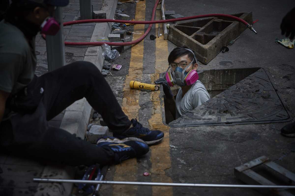 A protester emerges from a sewer in a failed escape from the besieged Hong Kong Polytechnic University.