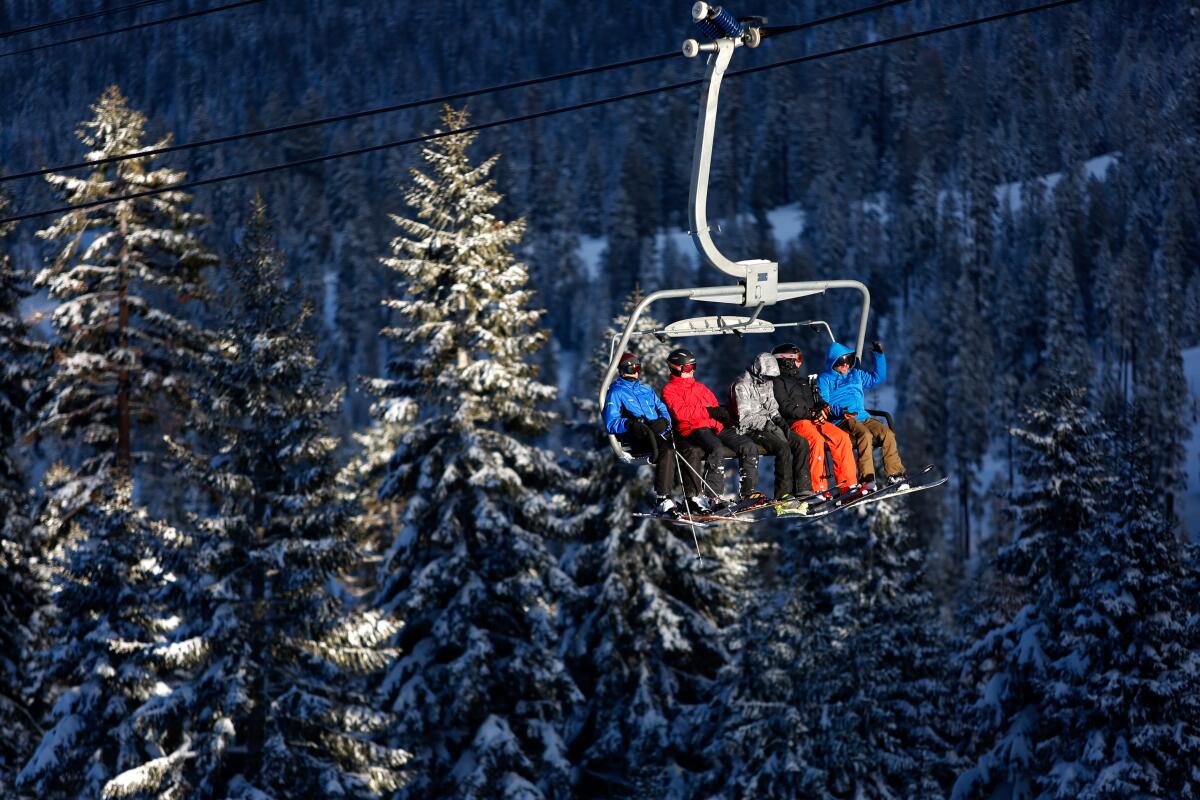 A group of skiers riding a ski lift.