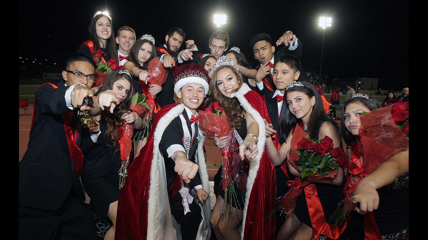 Homecoming king and queen Steven Blugrind and Erika Byron jump together with the rest of the homecoming court at Glendale High School for homecoming on Friday, November 6, 2015.