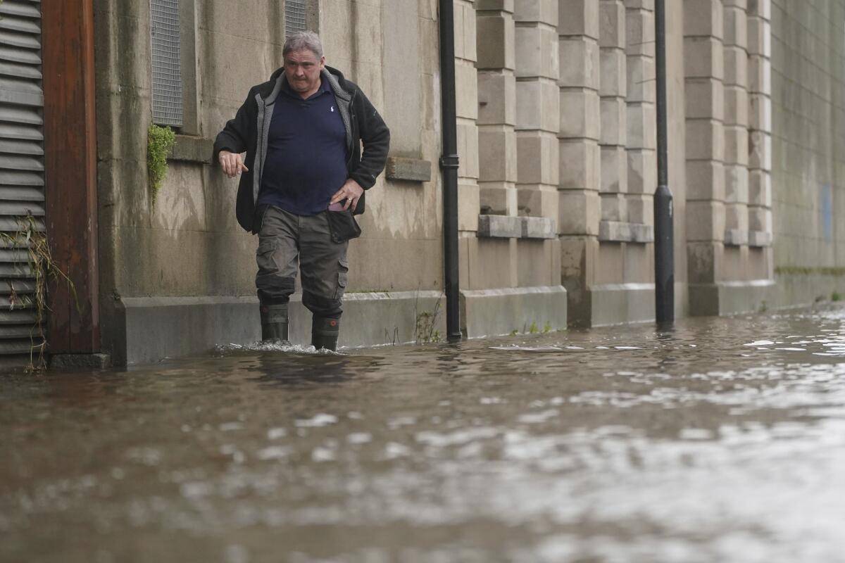 A man walks down a street through ankle-high water