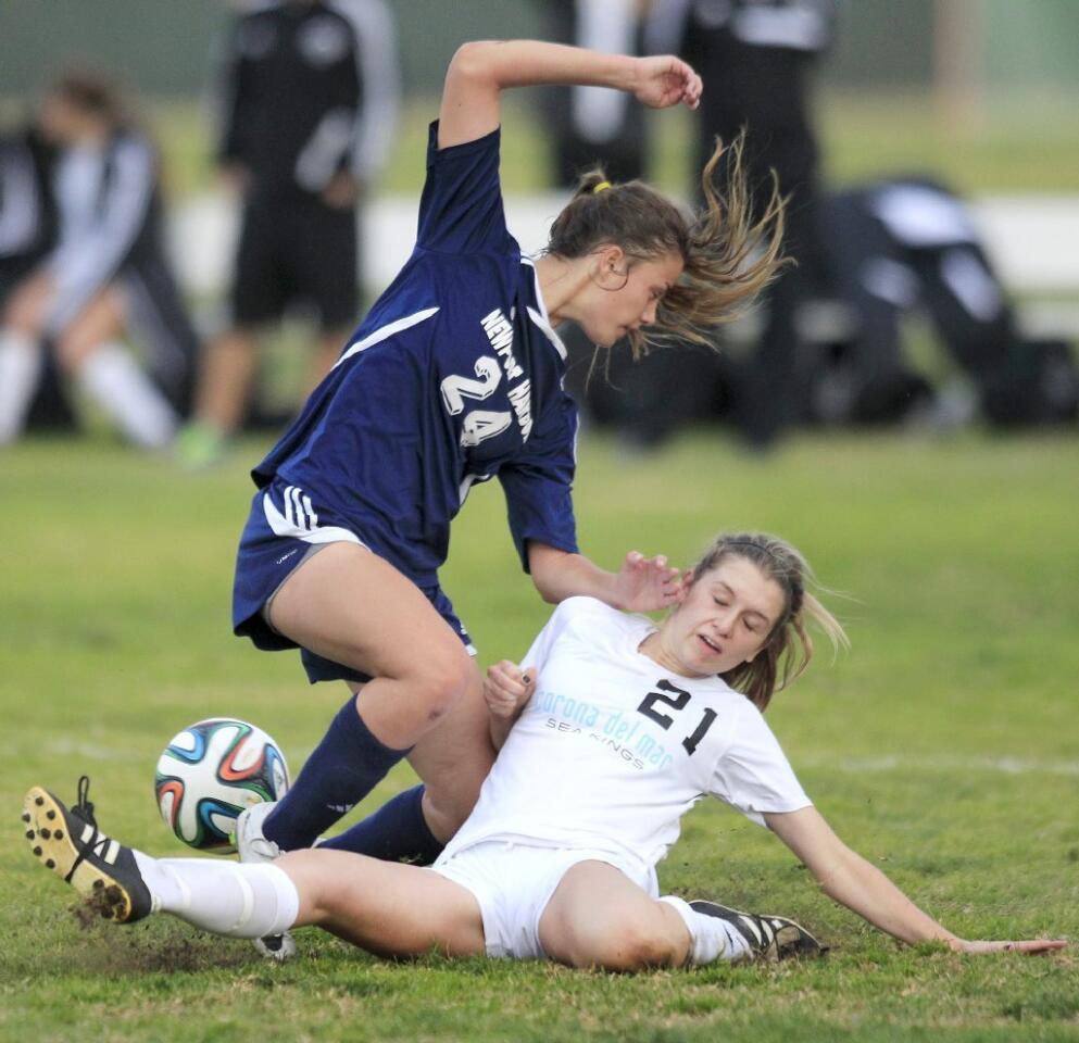 Corona del Mar High's Allie Doherty (21) slides as she knocks the ball away from Newport Harbor's Sianna Siemonsma (24) during the second half in the Battle of the Bay on Tuesday.