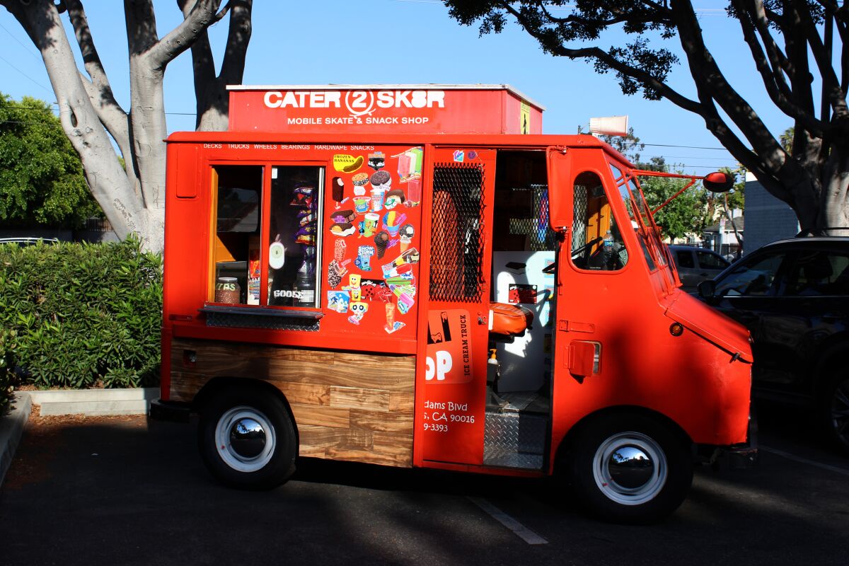 An orange truck with stickers of ice cream flavors.