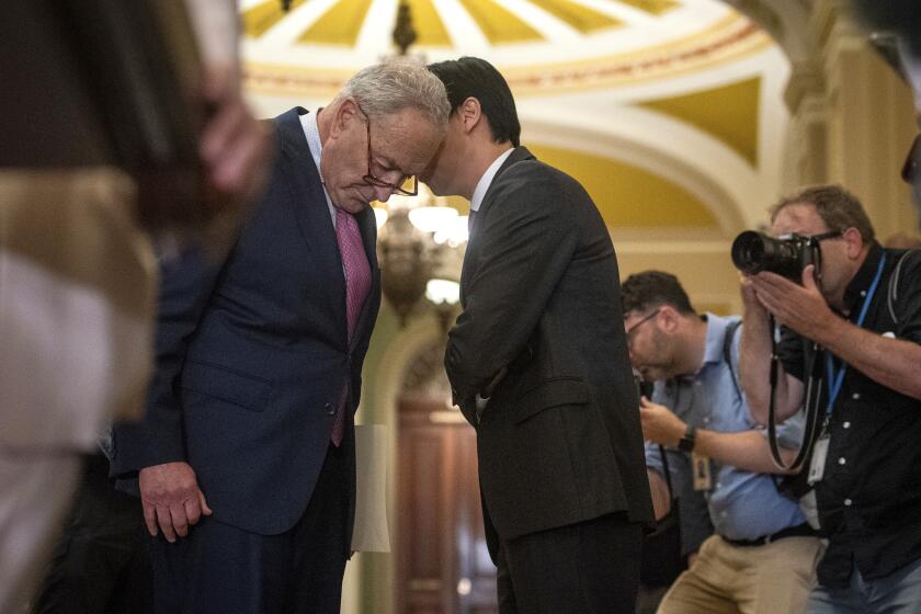 Senate Majority Leader Chuck Schumer, D-N.Y., left, speaks with Alex Nguyen, his communications director, while addressing reporters on Capitol Hill in Washington, Tuesday, July 9, 2024. (AP Photo/Cliff Owen)