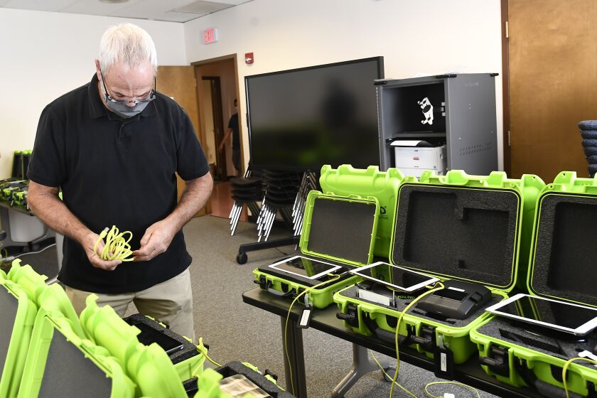 FILE - Mark Splonskowski assembles electronic poll book kits that voters will uses to sign in at polling locations at the Albany County Board of Elections building, Oct. 14, 2020, in Albany, N.Y. Attempts to develop the first-ever national standards for electronic voter rolls, the source of problems and hacking concerns in previous elections, may not be ready or available for wide use in time for the 2024 presidential election, concerning election experts. (AP Photo/Hans Pennink, File)