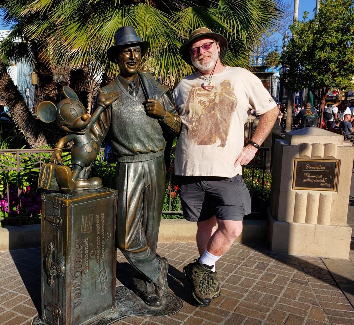 Jeff Reitz, standing next to a statue of Walt Disney and Mickey Mouse