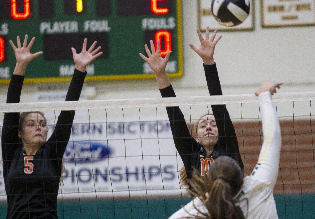 Huntington Beach's Mahina Williamson, left, and Bailey Nelson attempt to block a shot against Edison's Lindsey Sparks.