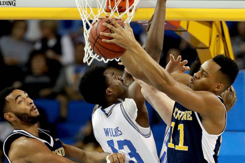 LOS ANGELES, CALIF. -- SUNDAY, NOVEMBER 26, 2017: UCLA Bruins guard Kris Wilkes (13) fights for a rebound against UC Irvine Anteaters forward Jonathan Galloway (5) and UC Irvine Anteaters forward John Edgar Jr. (11) in the first half at Pauley Pavilion in Los Angeles, Calif., on Nov. 26, 2017. UCLA won 87-63. (Gary Coronado / Los Angeles Times)