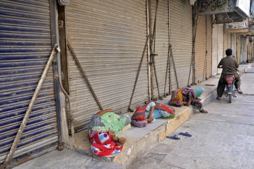 Unas paquistaníes duermen en el piso luego de que los comerciantes cerraron sus negocios durante una huelga contra la inflación en Hyderabad, Pakistán, el sábado 2 de septiembre de 2023. (AP Foto/Pervez Masih)