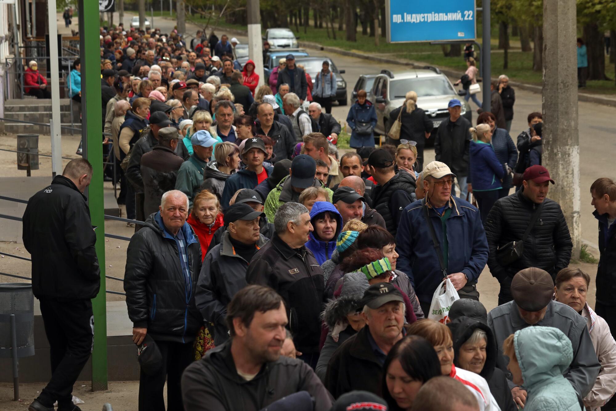 People line up at a post office in Kharkiv, that is now a food distribution center. 