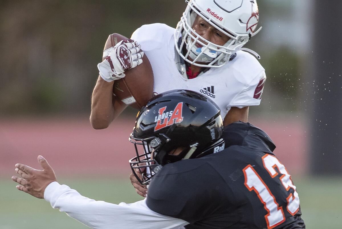 Los Amigos' Joseph Hernandez puts a hit on Ocean View's Jose Cholula after catching a pass.