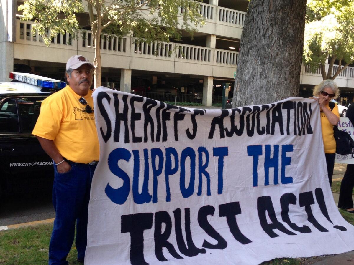 Advocates rally in front of the Sacramento headquarters of the California State Sheriffs' Assn. on Wednesday in favor of the Trust Act. The anti-deportation measure, which passed the Legislature last week, now awaits Gov. Jerry Brown's signature.